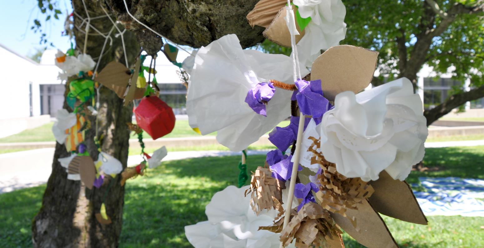 A grouping of found material mobiles attached to an apple tree outside the museum.