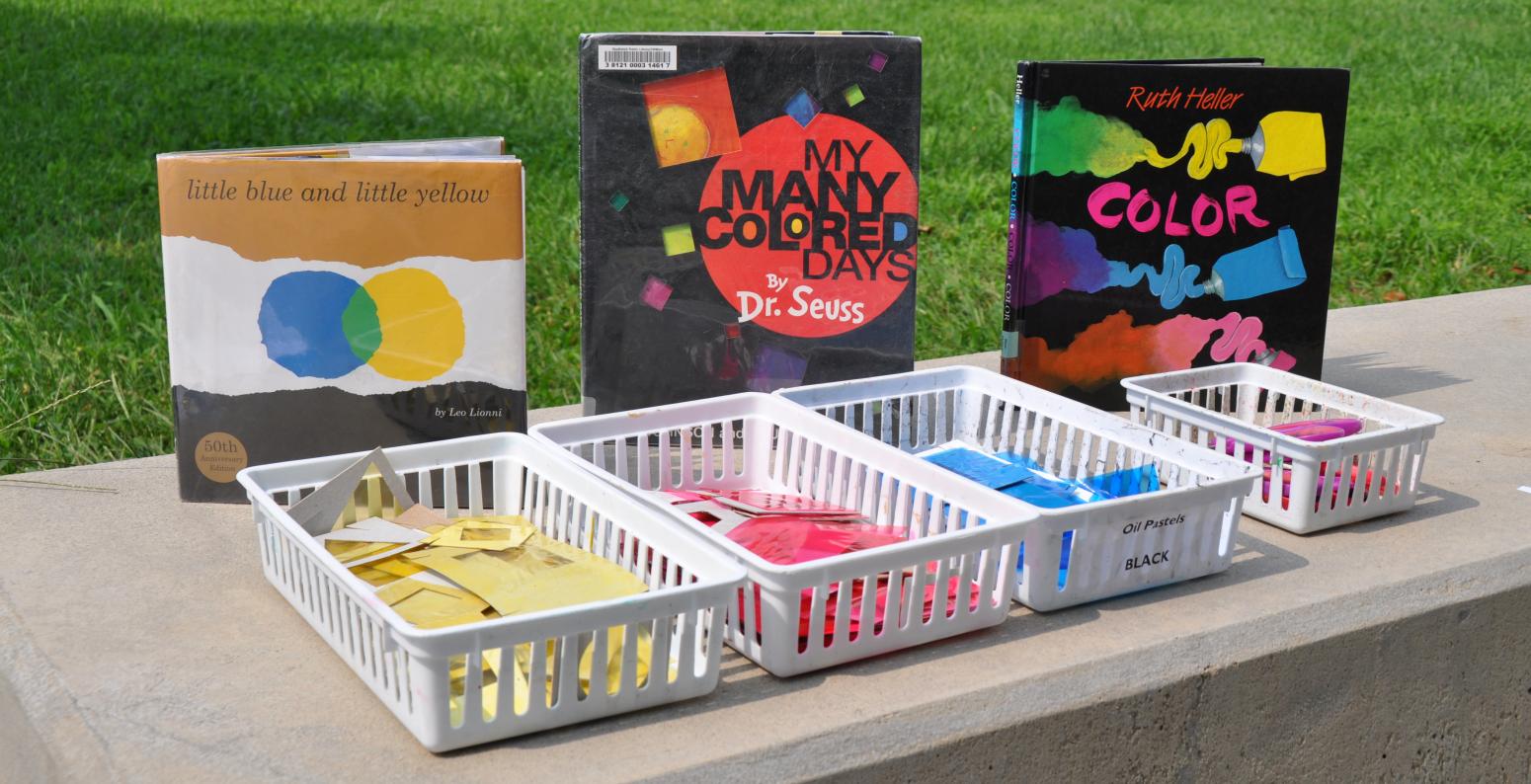 Baskets of colorful papers with picture books behind them.