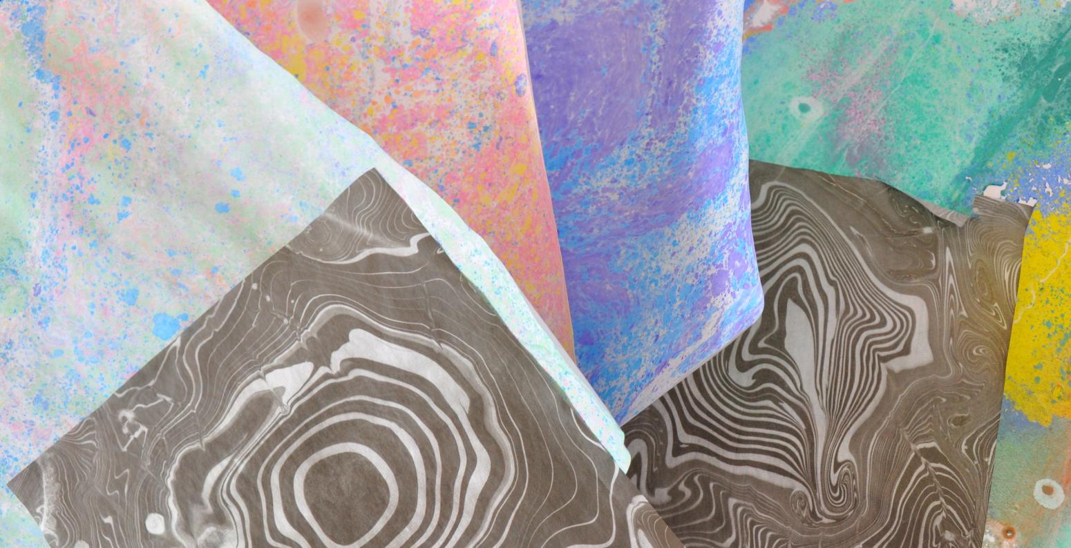 A pile of marbled papers of various colors and textures.