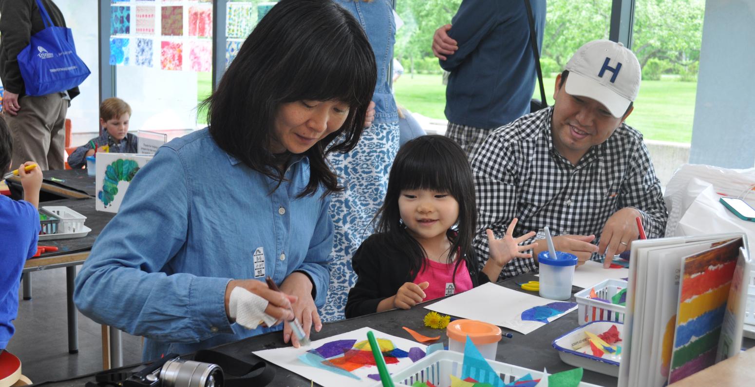 A family sits in the Art Studio making collage art creations.