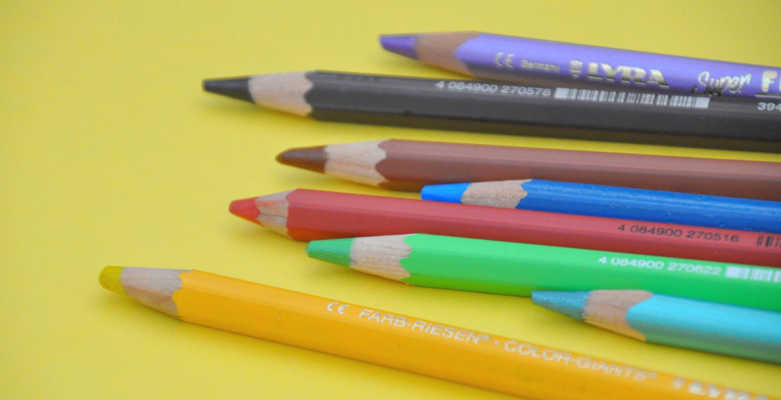 Several colorful colored pencils lined up next to each other.