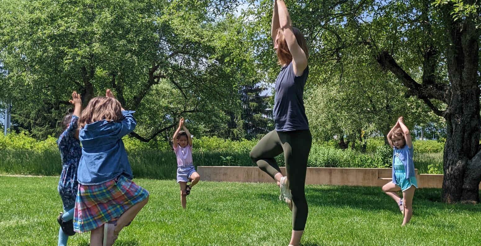 Photo of children outside dancing alongside instructor.