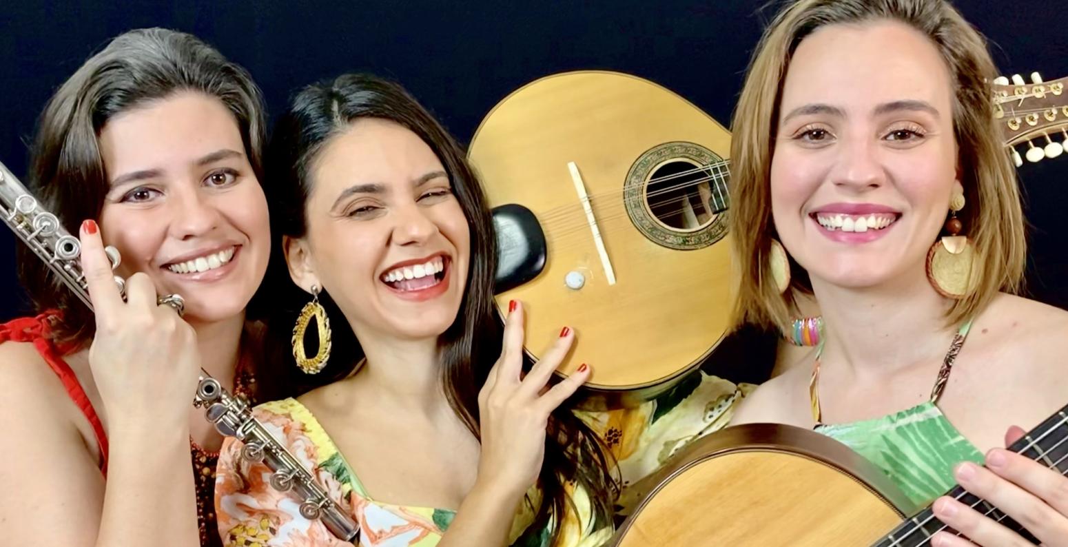 Three musicians smiling with instruments.