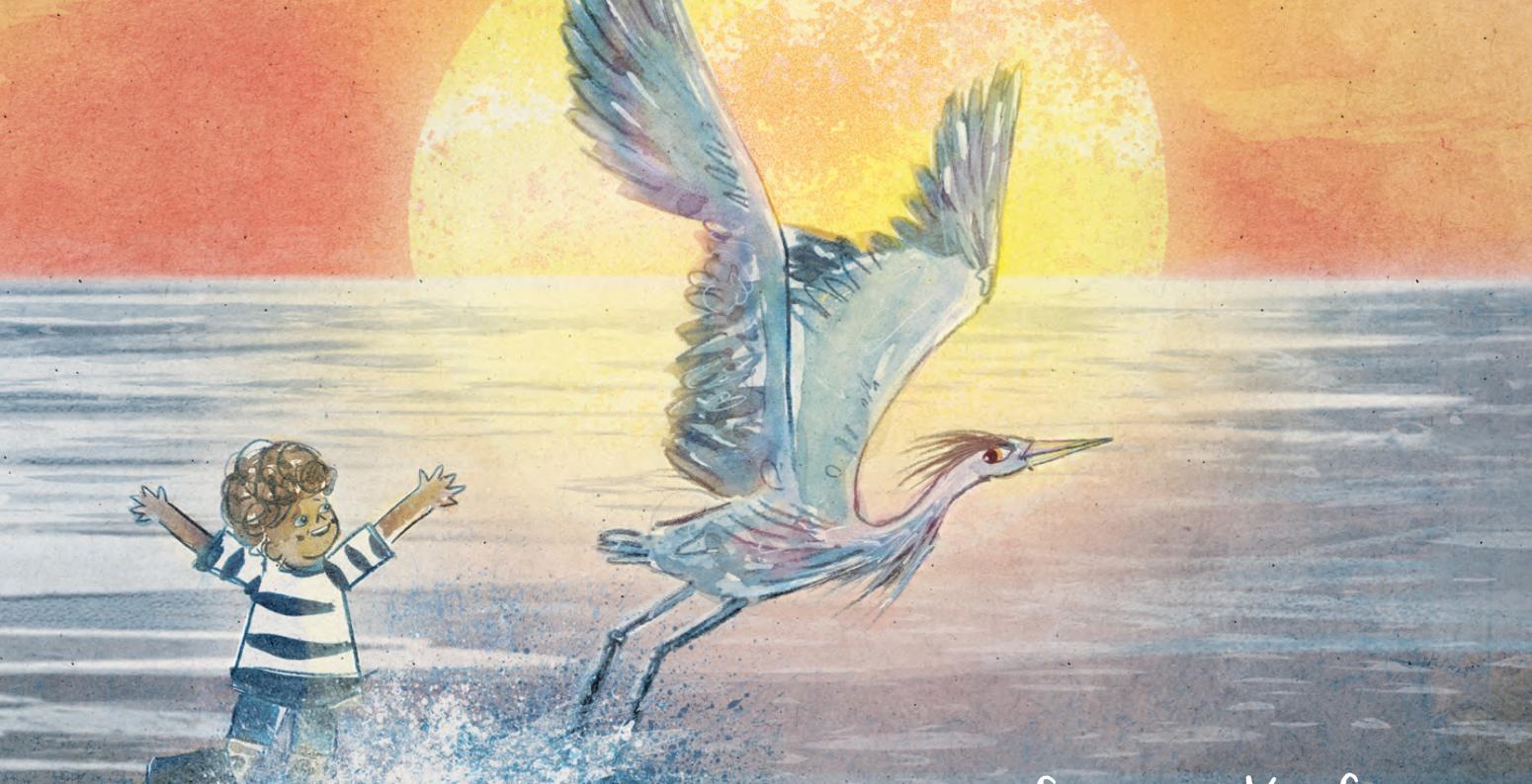 a boy in a striped shirt playing with a heron in the ocean
