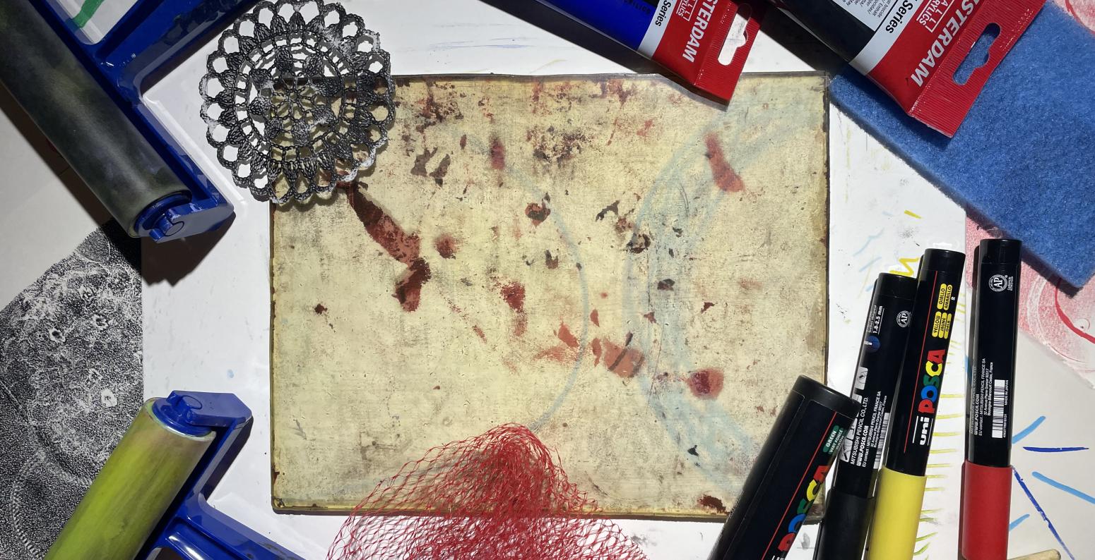 photograph of some printmaking brayers, a gelli plate, acrylic inks and acrylic markers.