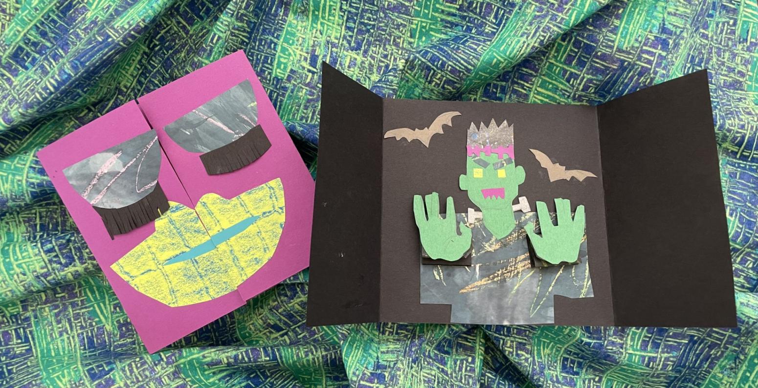 Two gate fold pop up books with a characters hands popping forward