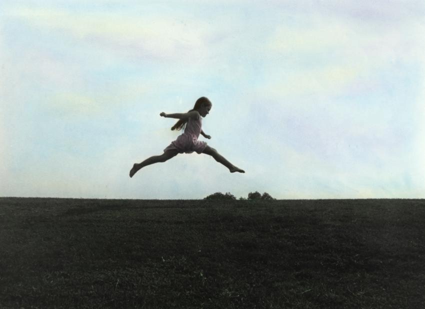 child leaping in a field