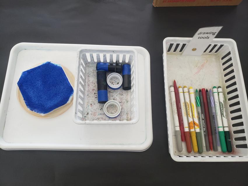 A homemade stamp pad, homemade stamps and a basket of drawing tools.