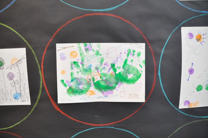 A stamp drawing that includes green handprints.