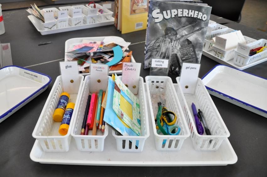 Baskets filled with art materials: colorful papers, glue sticks, scissors, and drawing tools.
