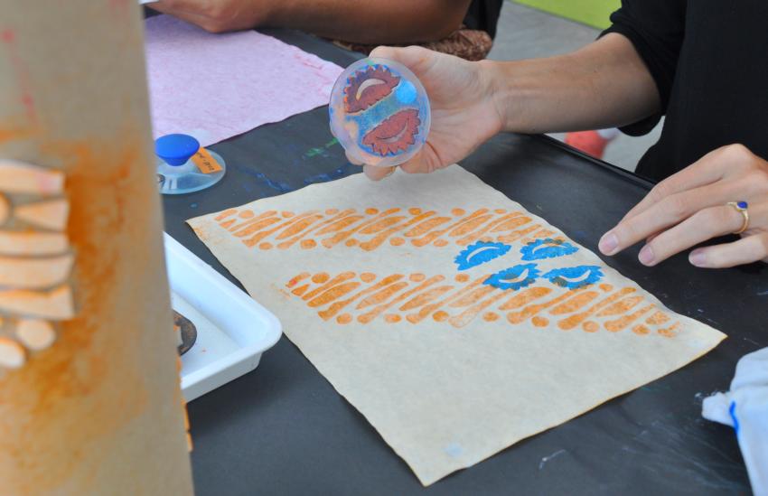 One of our guests trying Durian Pecah batik stamp on a dyed paper.