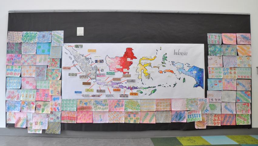 Guests’ batik papers displayed on the wall surrounding the Indonesian collaged map.