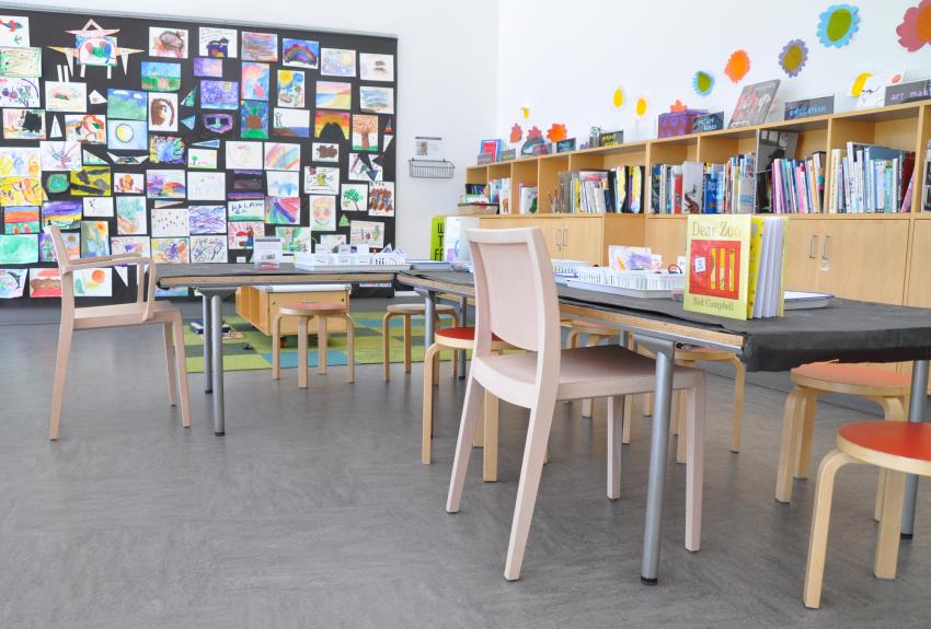 Wooden chairs next to stools at a table in the Art Studio.