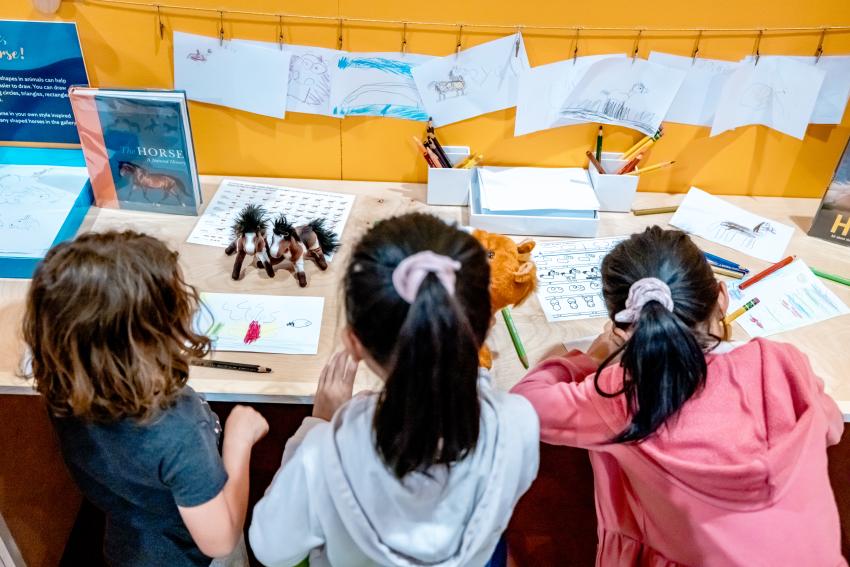 Photograph of children drawing horses. 