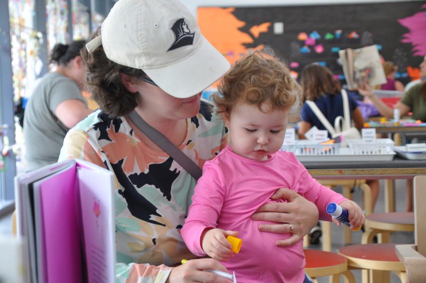 A young guest explores glue and its sticky qualities.