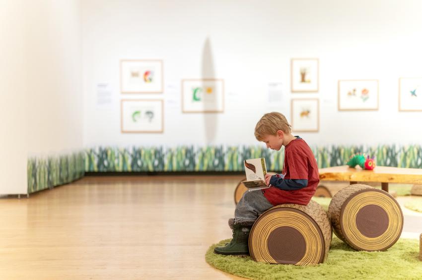 Photograph of child reading in gallery. 