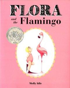 A child in a swim cap, flippers and pink leotard stands on one foot looking up at a flamingo.