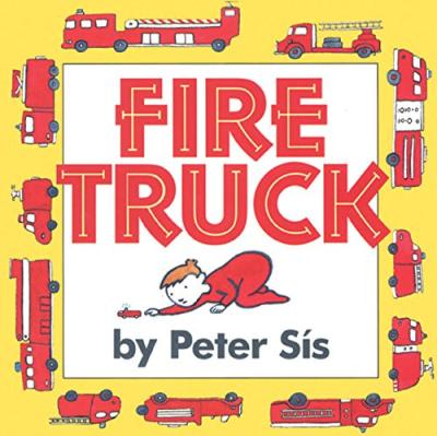 A child in red pajamas plays with a red toy fire truck.