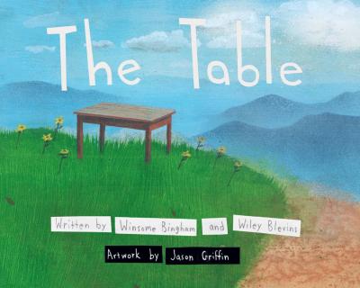 a wooden table standing on a grassy hill