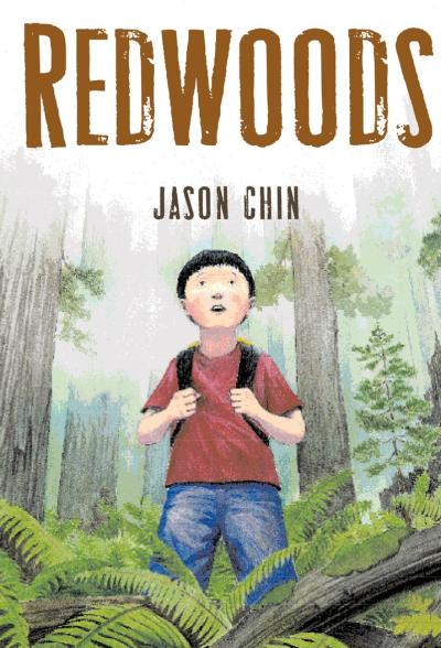 a boy standing in a grove of redwood trees