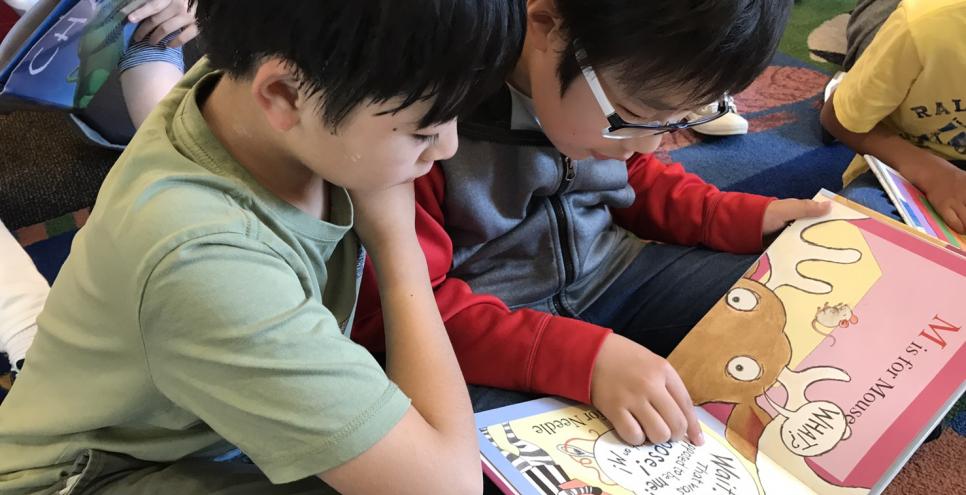 Two students reading a picture book together