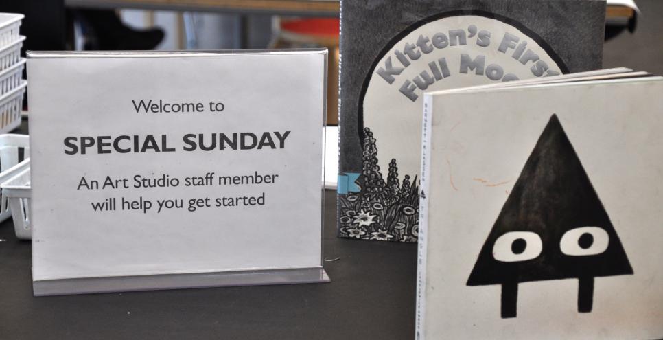 A sign welcoming guests to participate in a Special Sunday project and two picture books, Triangle, and Kitten's First Moon.