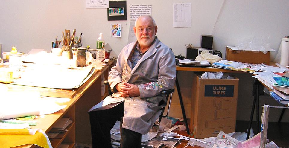 Eric Carle in his studio with cut papers. 