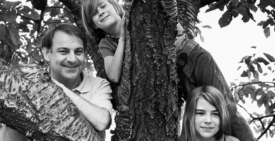 black and white photograph of Eric Carle and his son and daughter in a tree