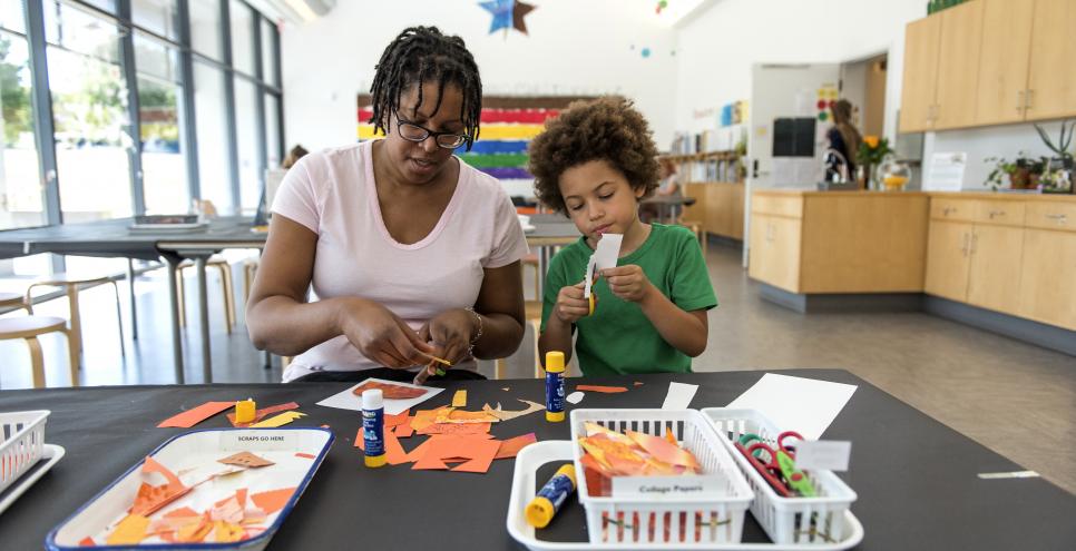 An adult and child making a collage in the Art Studio