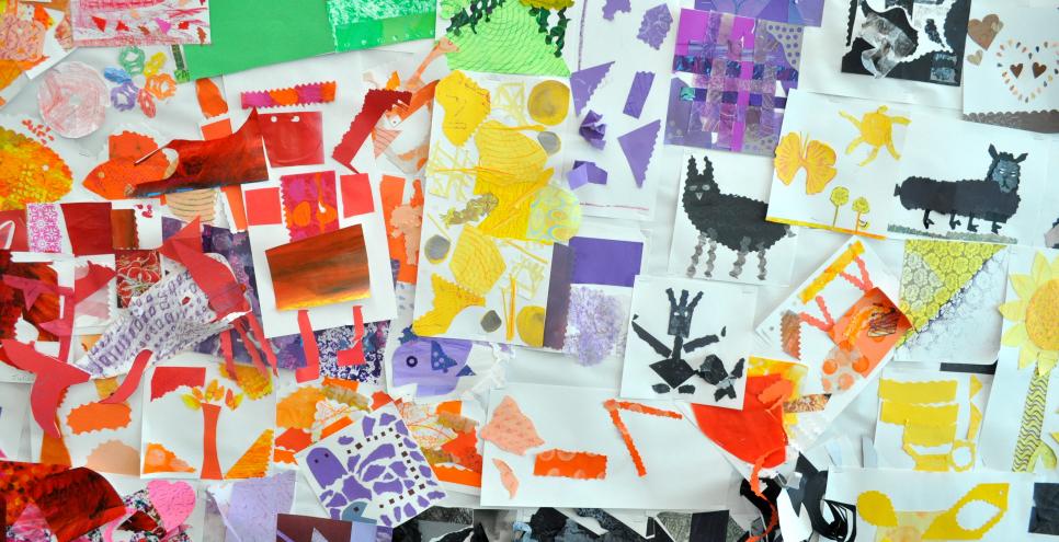 A wall covered in colorful collages on white background papers.
