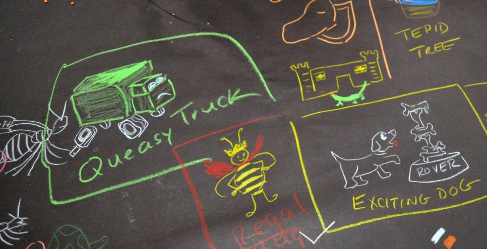 Drawings on black table covers including a queasy truck, tepid tree, elegant museum, and regal bug. 