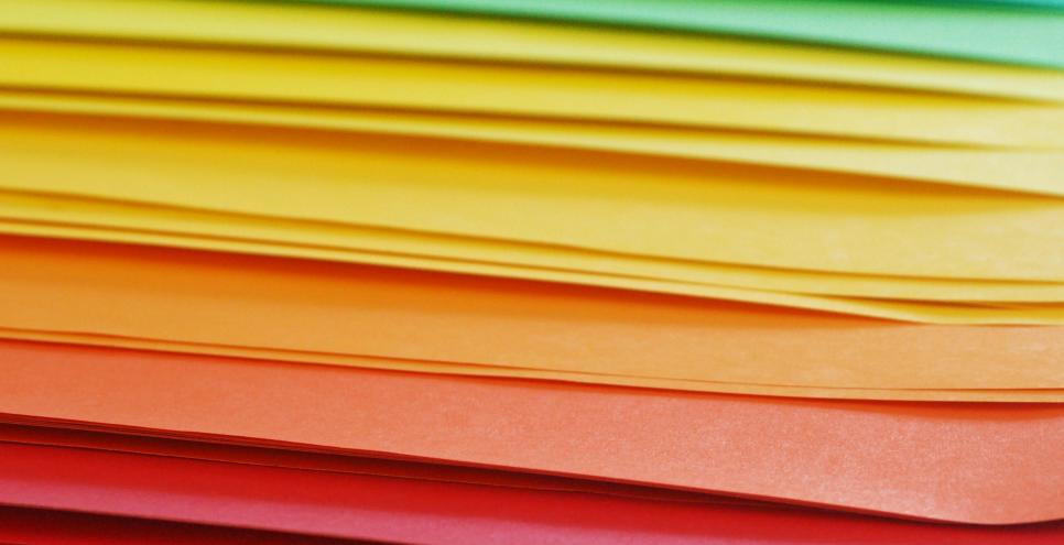An array of colorful papers arranged in rainbow order.