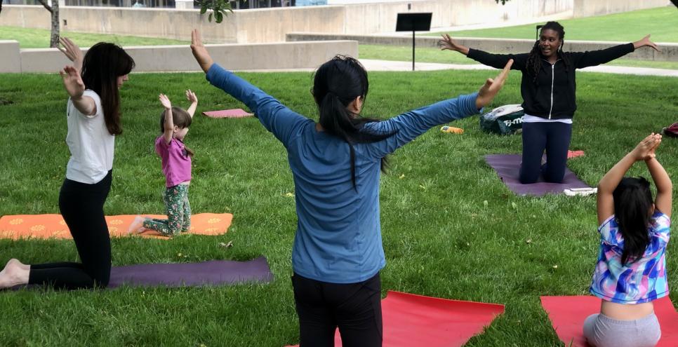 Yoga instructor and families doing yoga in Bobbie's Meadow.