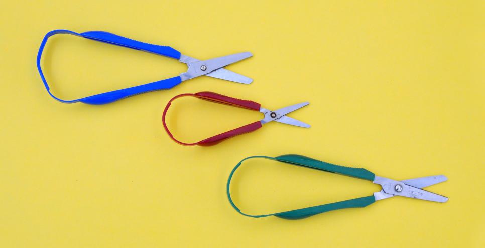 Three loop scissors with handles that are attached together in one continuous loop of plastic.