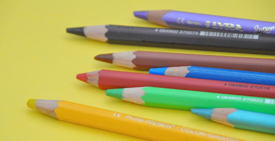 Several colorful colored pencils lined up next to each other.