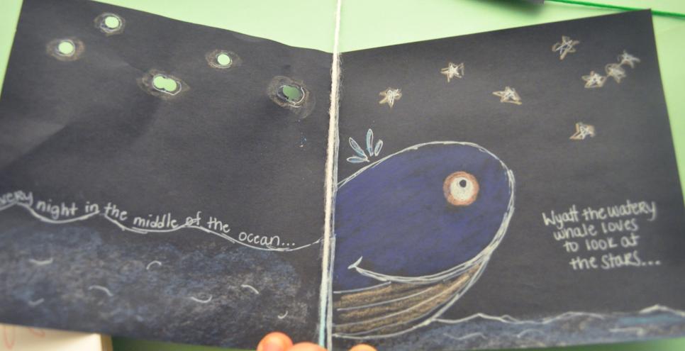 A book with a drawn whale named Wyatt who is looking out into a night sky with stars.