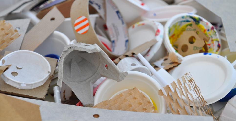 A large bin filled with a variety of cardboard and paper materials that have been previously used in art projects.