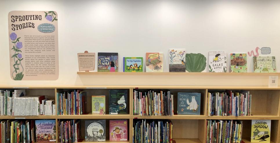 The exhibition wall text for the Reading Library exhibition ”Sprouting Stories” with the first few books displayed on a shelf.  