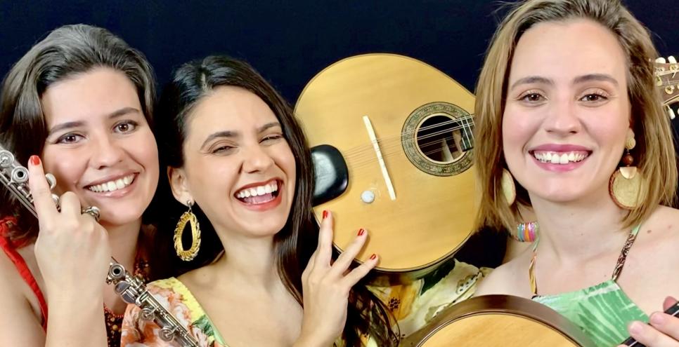 Three musicians smiling with instruments.