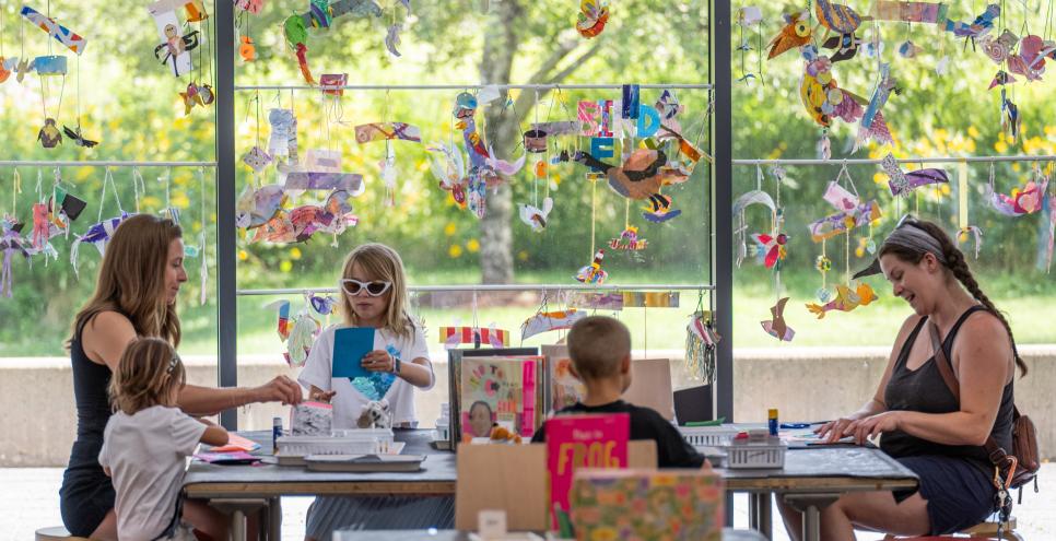 adults and kids in the art studio sitting at a table making art
