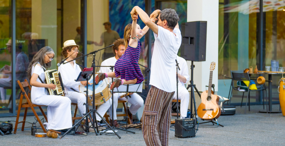 adult and child dancing near live band