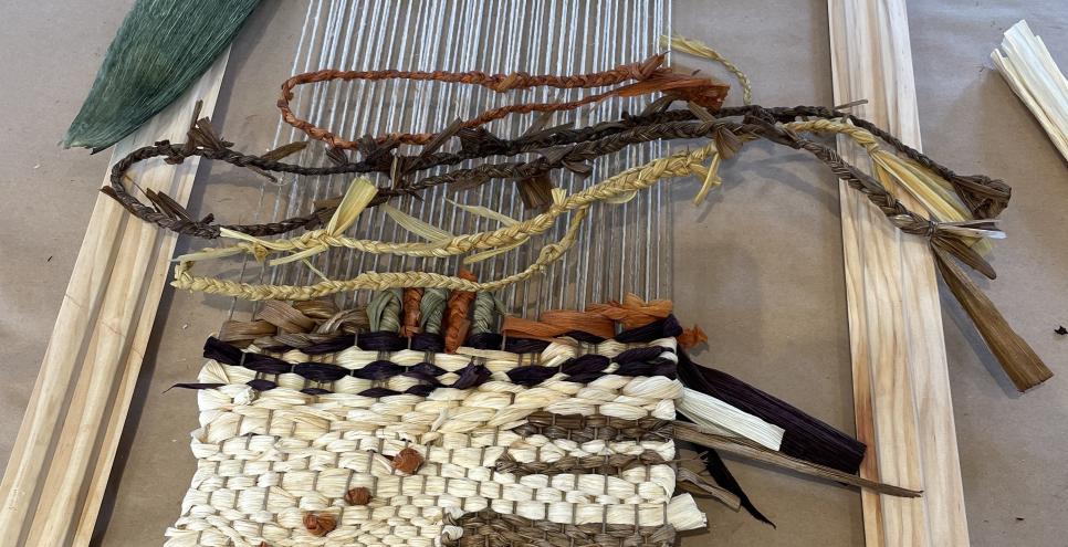 loom with cornhusk weaving in different shades from natural to dark brown and green