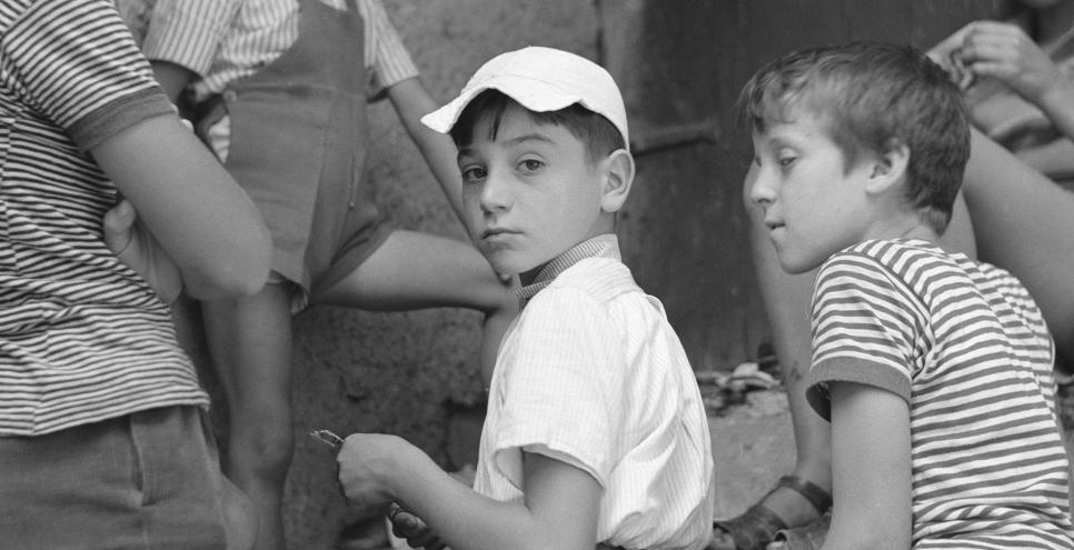 Photograph of kids sitting on stoop. 