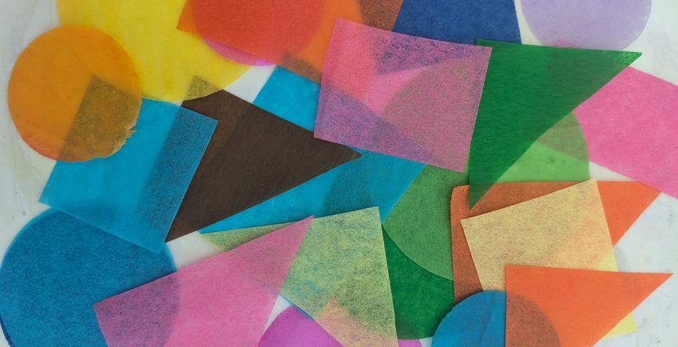 A variety of colorful tissue paper shapes overlapping one another.