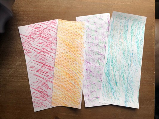 Four papers with different texture rubbings including red diamonds and orange chevrons.
