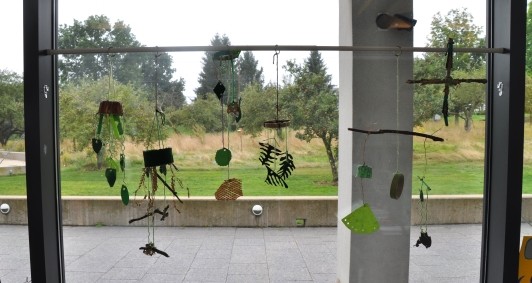 Window display with 6 plant-inspired mobiles hanging