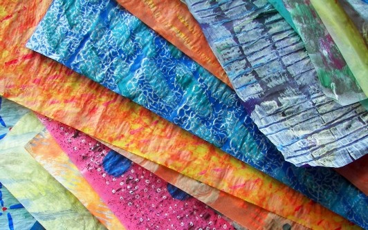 Stack of painted papers with various textures, colors, and patterns.